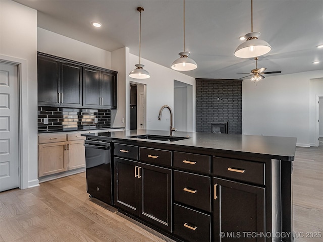 kitchen with sink, black dishwasher, pendant lighting, a kitchen island with sink, and decorative backsplash