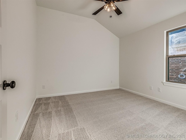 carpeted spare room featuring vaulted ceiling and ceiling fan