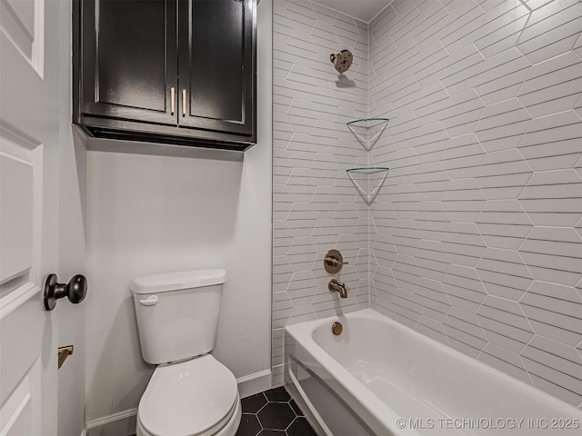 bathroom with tile patterned flooring, tiled shower / bath, and toilet