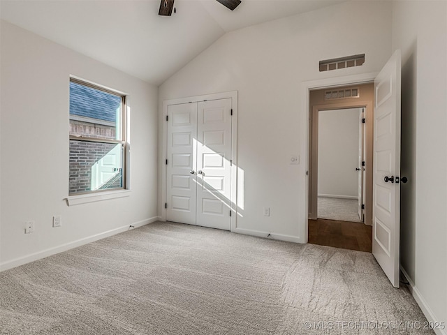 unfurnished bedroom with ceiling fan, lofted ceiling, carpet flooring, and a closet