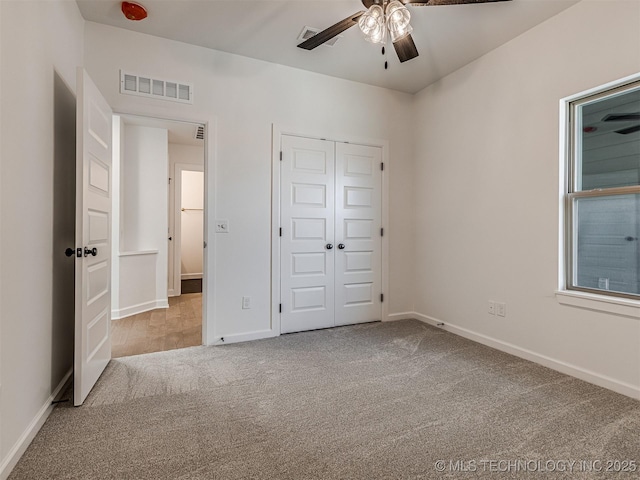 unfurnished bedroom featuring light colored carpet, ceiling fan, and a closet