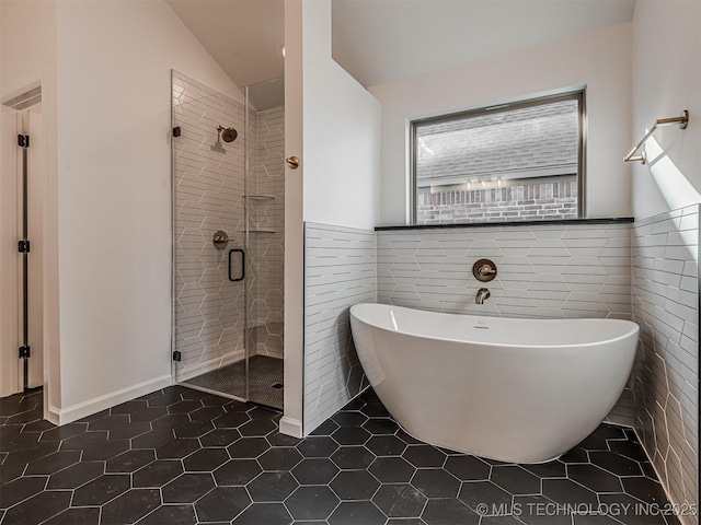 bathroom with tile walls, tile patterned floors, lofted ceiling, and plus walk in shower