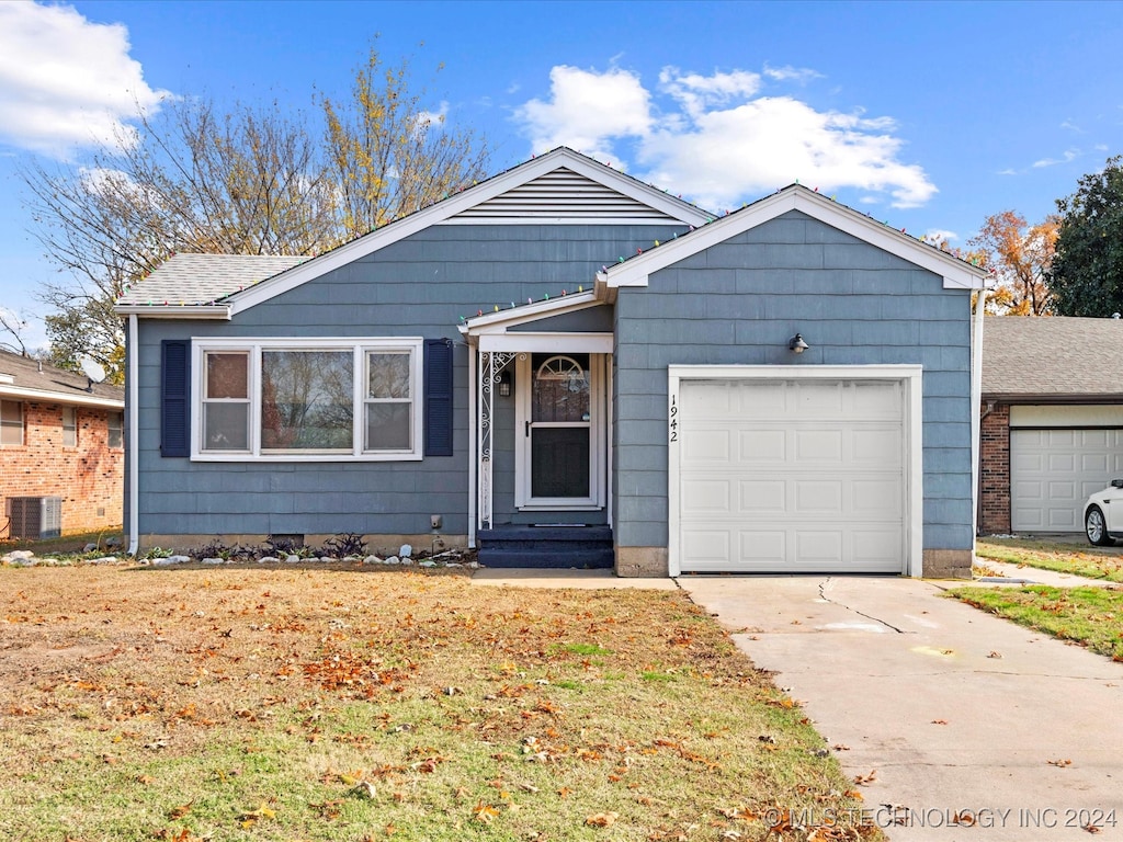 view of front of home with central air condition unit and a garage