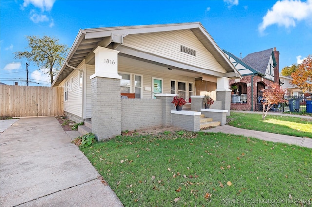 view of front of property featuring covered porch and a front yard