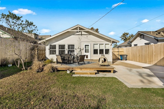 rear view of house with a yard and a wooden deck