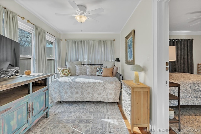 bedroom with light wood-type flooring, ceiling fan, and ornamental molding