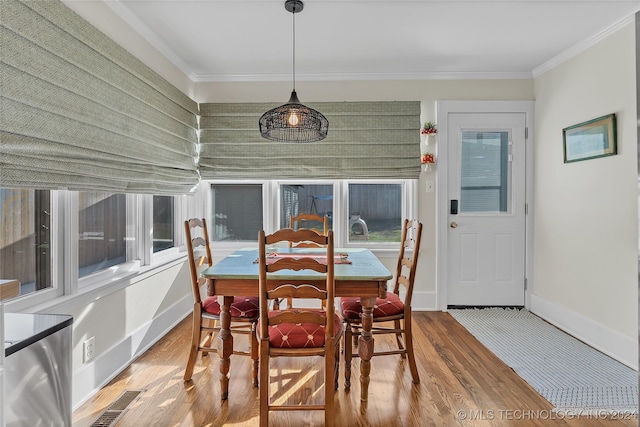 dining space featuring hardwood / wood-style flooring and ornamental molding