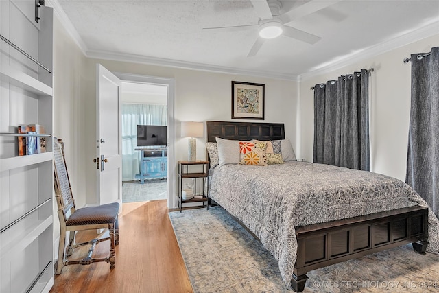 bedroom featuring ceiling fan, light hardwood / wood-style flooring, crown molding, and a textured ceiling