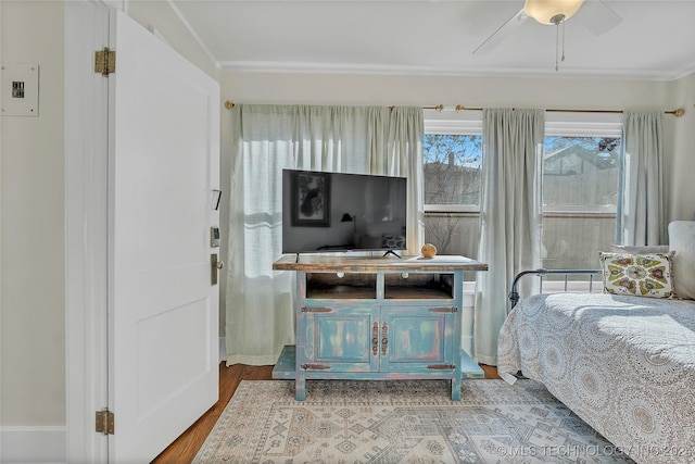 bedroom with ceiling fan, ornamental molding, and hardwood / wood-style flooring