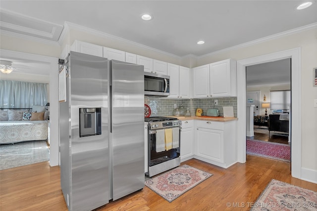 kitchen featuring stainless steel appliances, white cabinetry, crown molding, and light hardwood / wood-style flooring