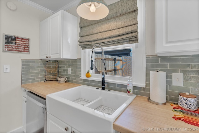 kitchen featuring decorative backsplash, stainless steel dishwasher, ornamental molding, sink, and white cabinetry