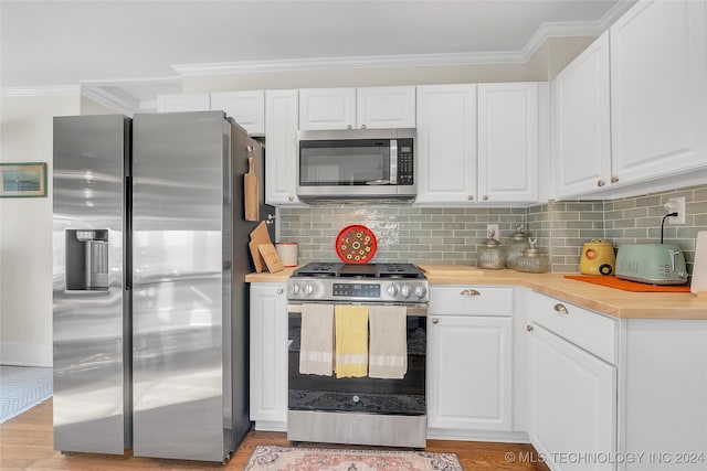 kitchen featuring crown molding, light hardwood / wood-style floors, decorative backsplash, white cabinets, and appliances with stainless steel finishes