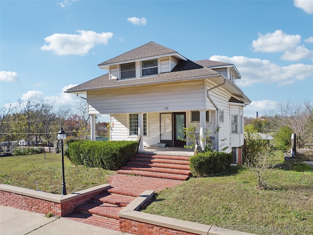 bungalow-style house featuring roof with shingles, a porch, and a front lawn