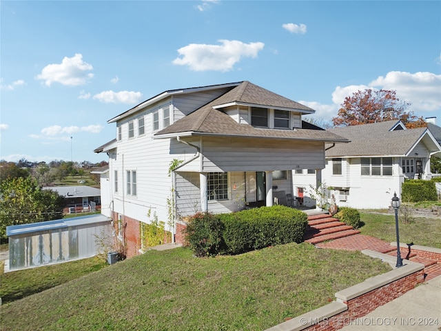 view of front of house featuring a front lawn and covered porch