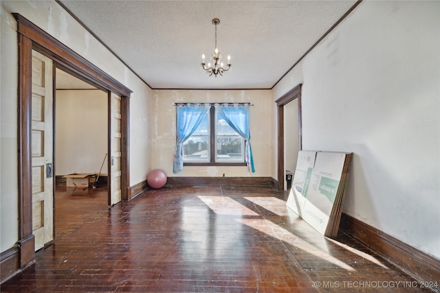 interior space with baseboards, a chandelier, ornamental molding, hardwood / wood-style flooring, and a textured ceiling