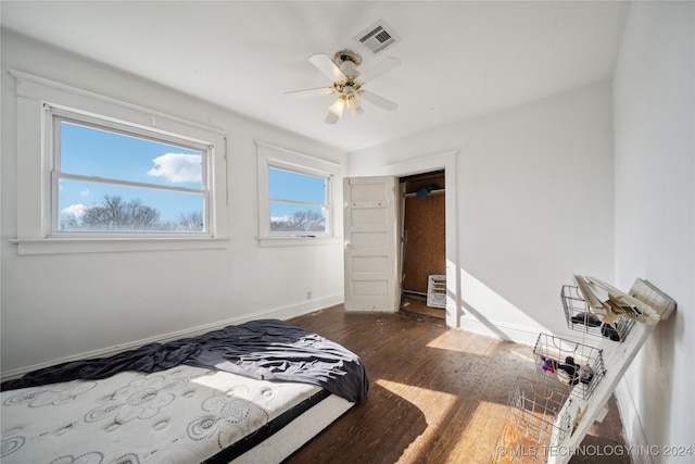 bedroom featuring a ceiling fan, baseboards, visible vents, and wood-type flooring