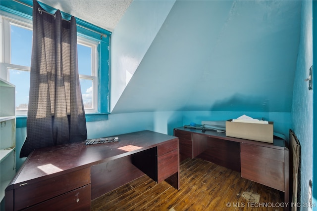 office area featuring a textured ceiling, wood finished floors, and vaulted ceiling