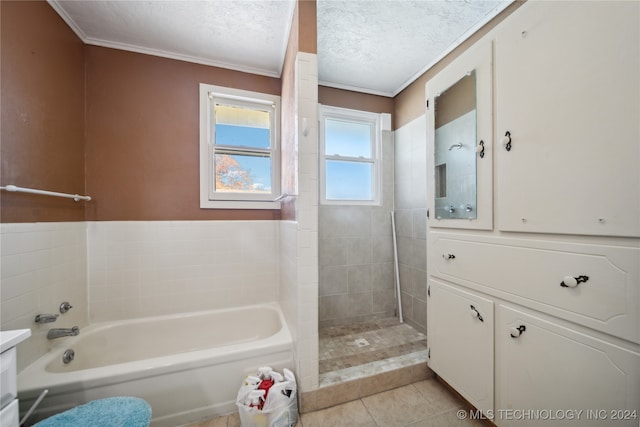 full bathroom with tile patterned flooring, vanity, a garden tub, tiled shower, and a textured ceiling