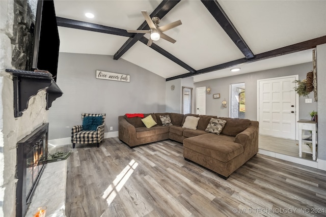 living room with hardwood / wood-style floors, vaulted ceiling with beams, and ceiling fan