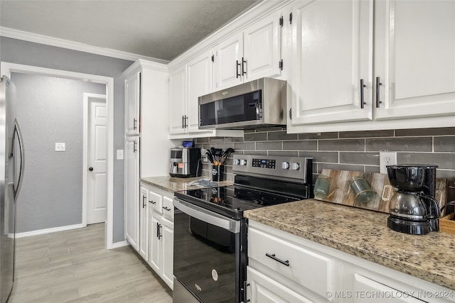 kitchen with white cabinetry, light stone countertops, stainless steel appliances, backsplash, and ornamental molding