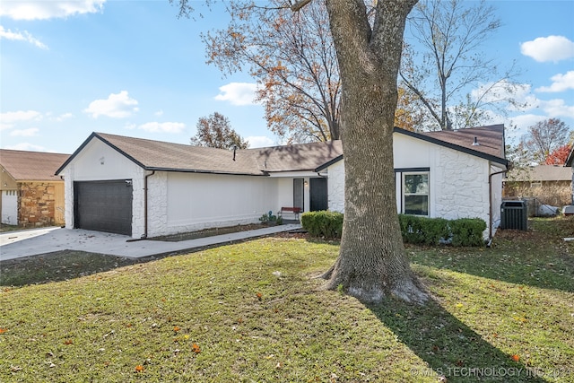 single story home with a garage, central air condition unit, and a front yard