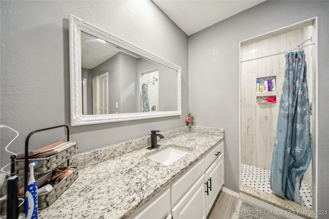 bathroom with hardwood / wood-style floors, a shower with curtain, and vanity