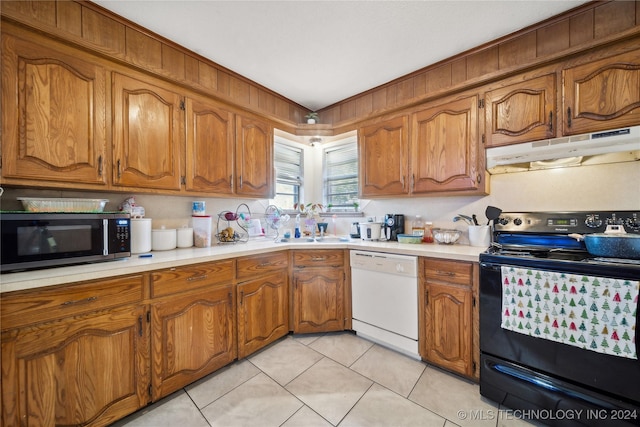 kitchen featuring dishwasher, black electric range oven, light tile patterned floors, and sink