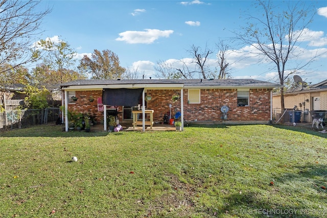 back of property with a yard and a patio