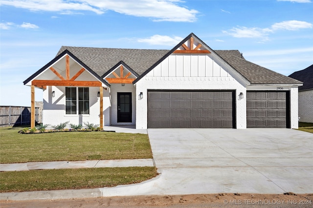 modern inspired farmhouse featuring a garage and a front lawn