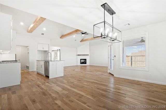 unfurnished living room featuring lofted ceiling with beams, sink, light wood-type flooring, and ceiling fan with notable chandelier