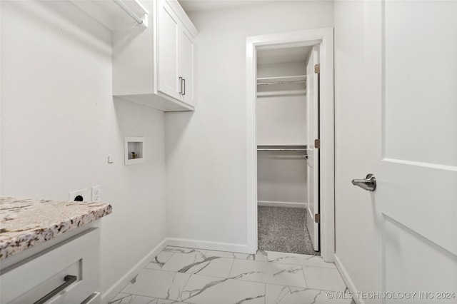 clothes washing area with hookup for a washing machine, cabinets, and hookup for an electric dryer