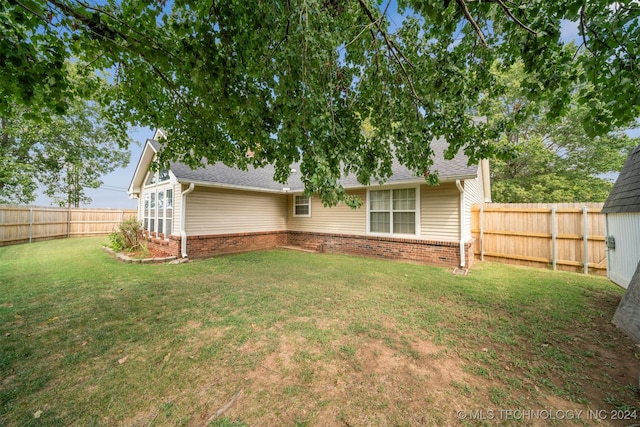 rear view of house featuring a yard