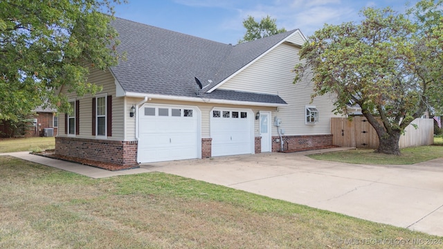 view of property exterior with a garage, central AC unit, and a lawn