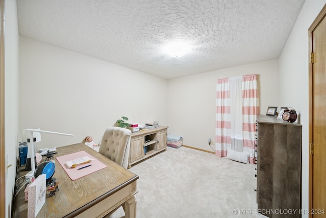 carpeted home office featuring a textured ceiling