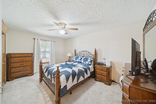 carpeted bedroom with ceiling fan and a textured ceiling