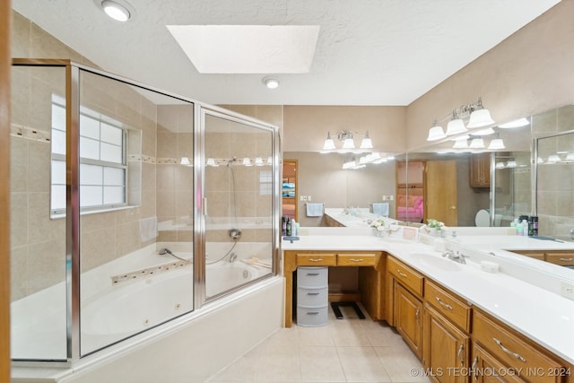 bathroom featuring a skylight, tile patterned flooring, vanity, and a textured ceiling