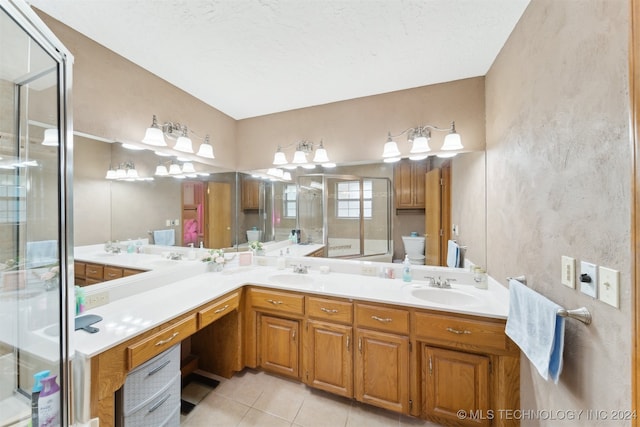 bathroom with tile patterned flooring, vanity, toilet, and walk in shower