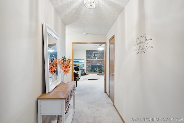 corridor featuring a textured ceiling and light carpet