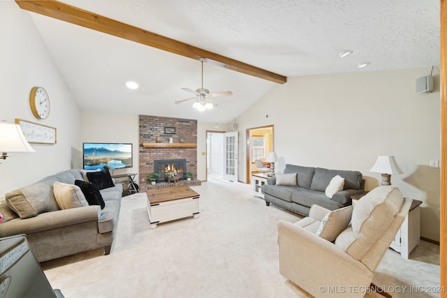 carpeted living room with a textured ceiling, vaulted ceiling with beams, a brick fireplace, and ceiling fan