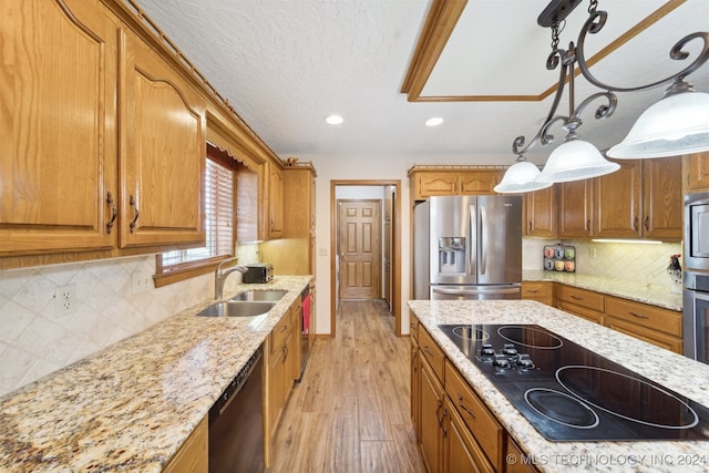 kitchen with backsplash, sink, black appliances, decorative light fixtures, and light hardwood / wood-style floors