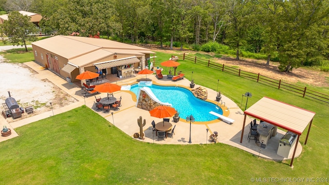 view of swimming pool with a patio area, a diving board, and a yard