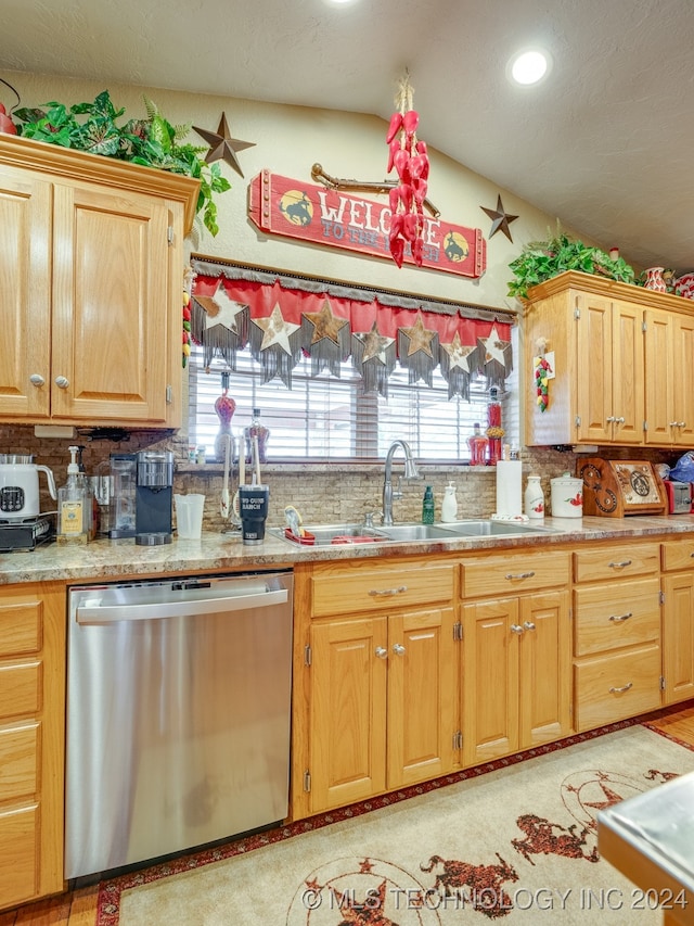 kitchen featuring tasteful backsplash, dishwasher, and sink