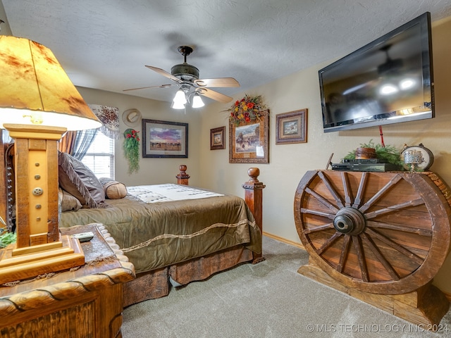 bedroom with ceiling fan, carpet floors, and a textured ceiling