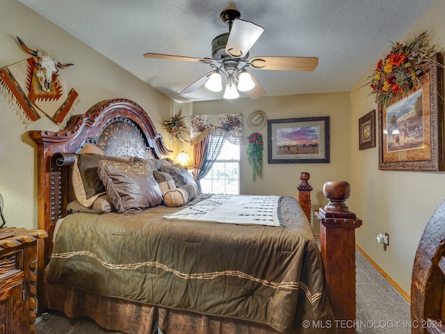 carpeted bedroom featuring ceiling fan and a textured ceiling