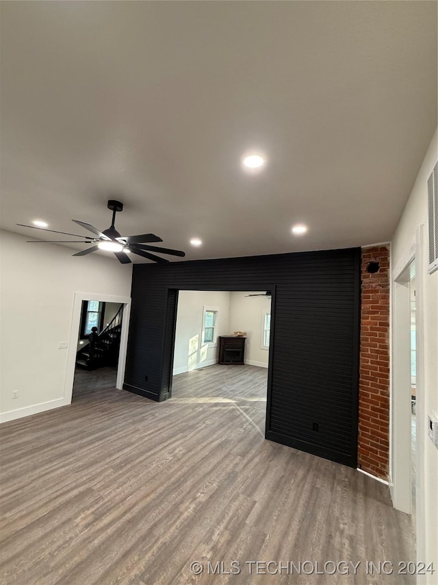 unfurnished living room featuring wood-type flooring and ceiling fan