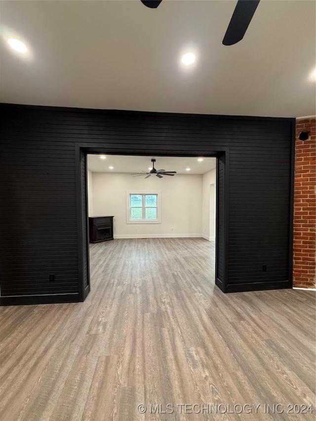 unfurnished living room with ceiling fan and light wood-type flooring