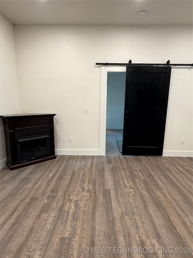 unfurnished room featuring hardwood / wood-style floors and a barn door