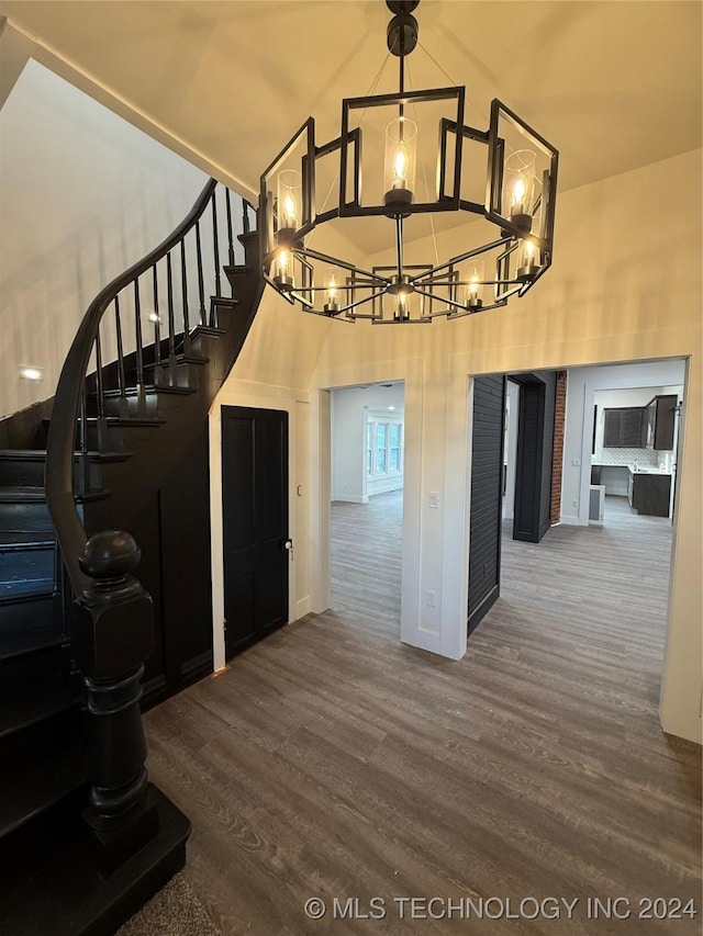 stairway with a high ceiling and hardwood / wood-style flooring