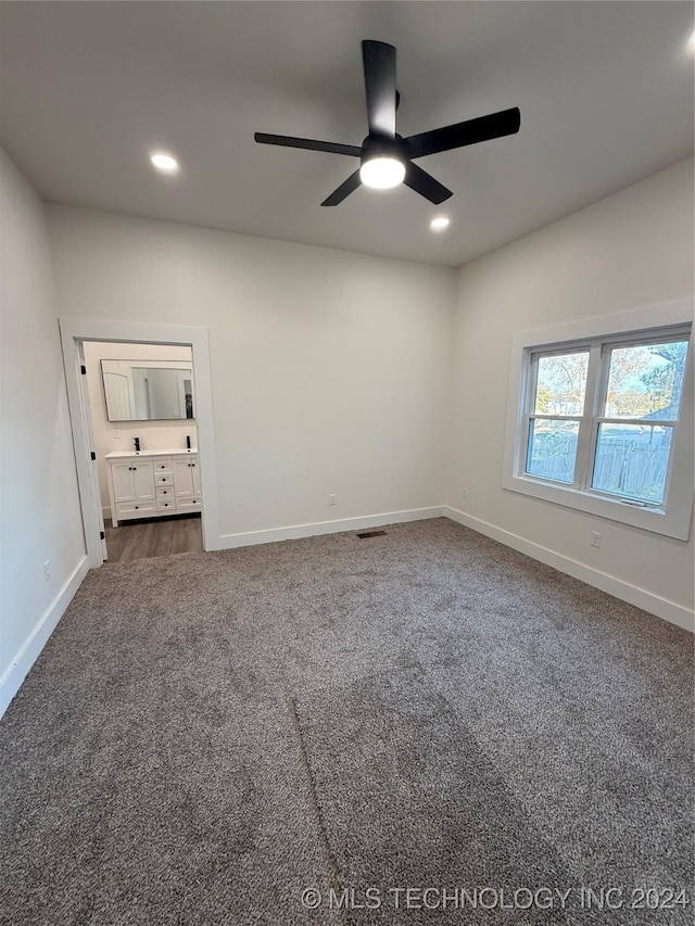 unfurnished bedroom with dark colored carpet and ceiling fan