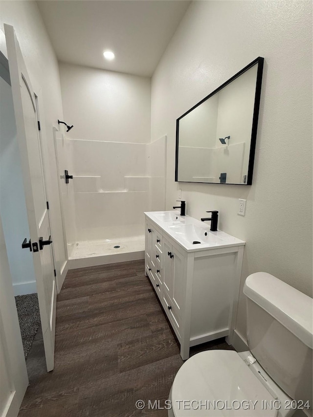 bathroom with vanity, toilet, wood-type flooring, and a shower